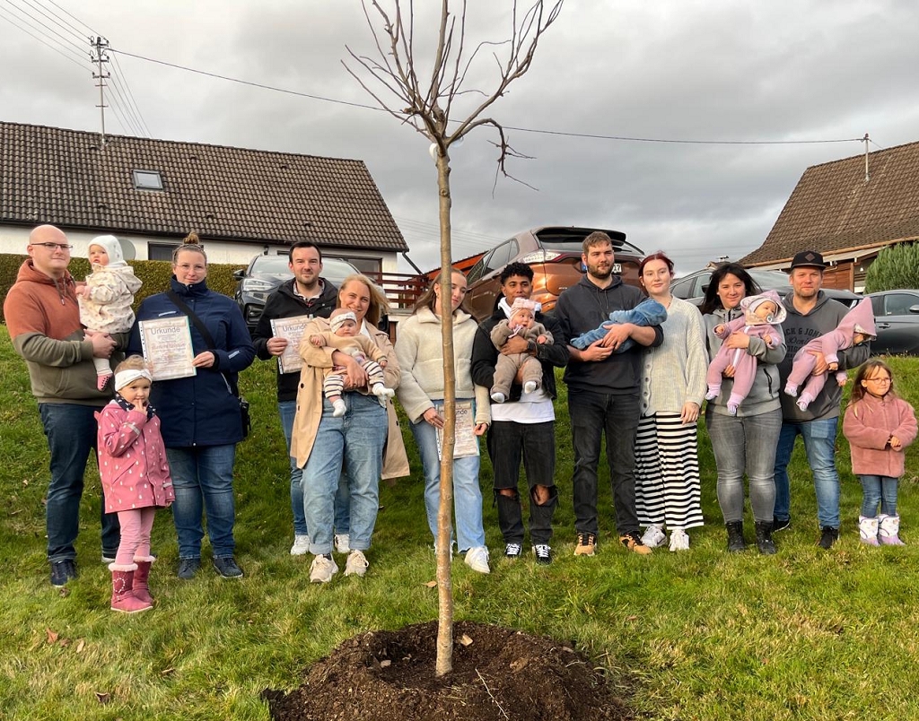 Die stolzen Eltern rund um den Geburtsbaum